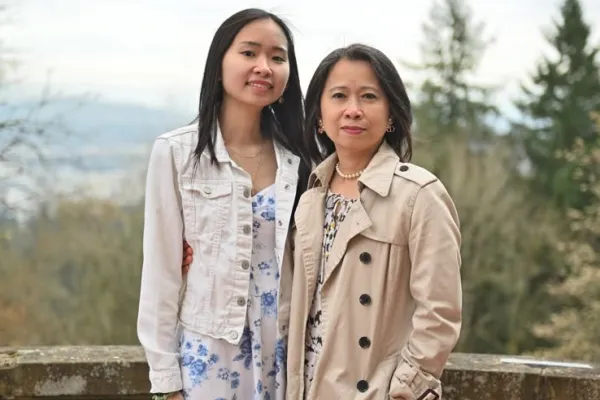 Sophia and Hoa posed together in front of a mountain.